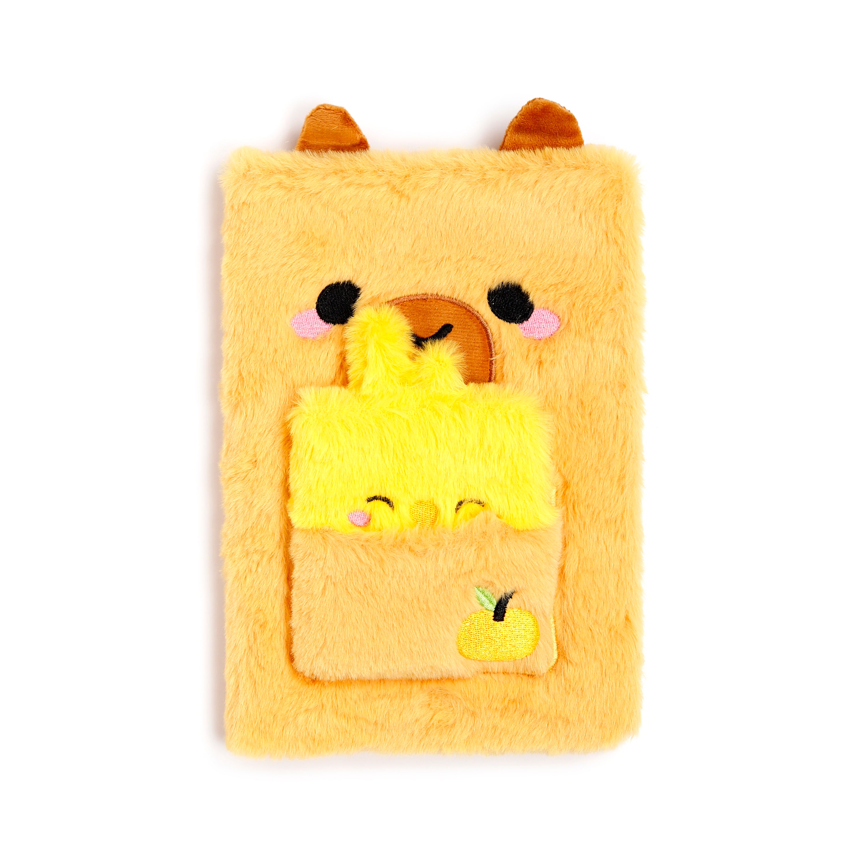 A soft, fuzzy brown capybara notebook with 3D ears and a small winking face, shown with a matching mini notebook stored in its plush belly pocket.
